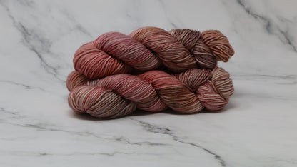 3 skeins of variegated yarn on a white marble surface and background