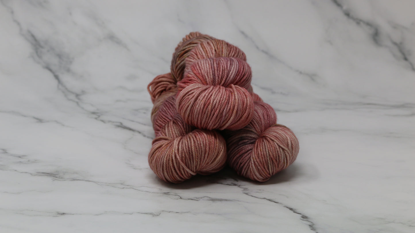 3 skeins of variegated yarn on a white marble surface and background