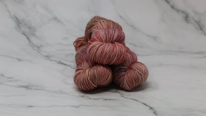 3 skeins of variegated yarn on a white marble surface and background