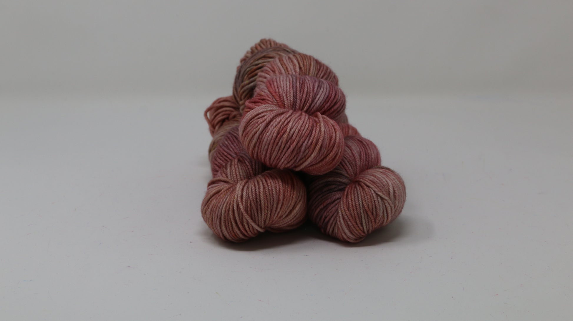 3 skeins of variegated yarn on a white surface and background