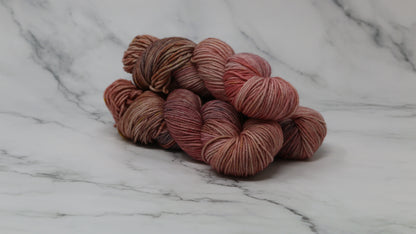 3 skeins of variegated yarn on a white marble surface and background