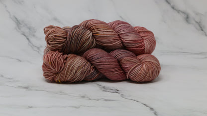 3 skeins of variegated yarn on a white marble surface and background