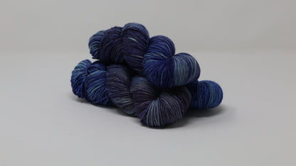 3 skeins of blue variegated yarn on a white background and surface