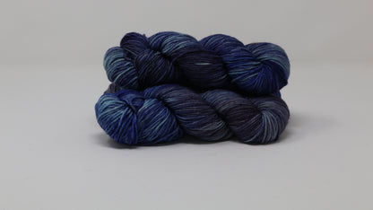 3 skeins of blue variegated yarn on a white background and surface