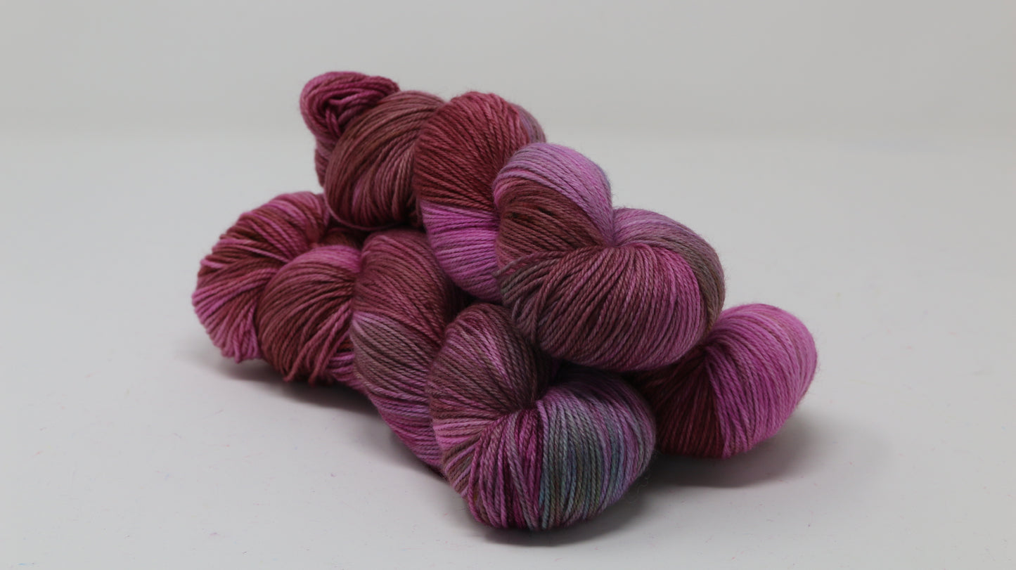 3 skeins of pink, red, green yarn