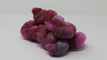 3 skeins of pink, red, green yarn