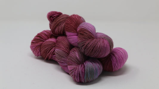 3 skeins of pink, red, green yarn