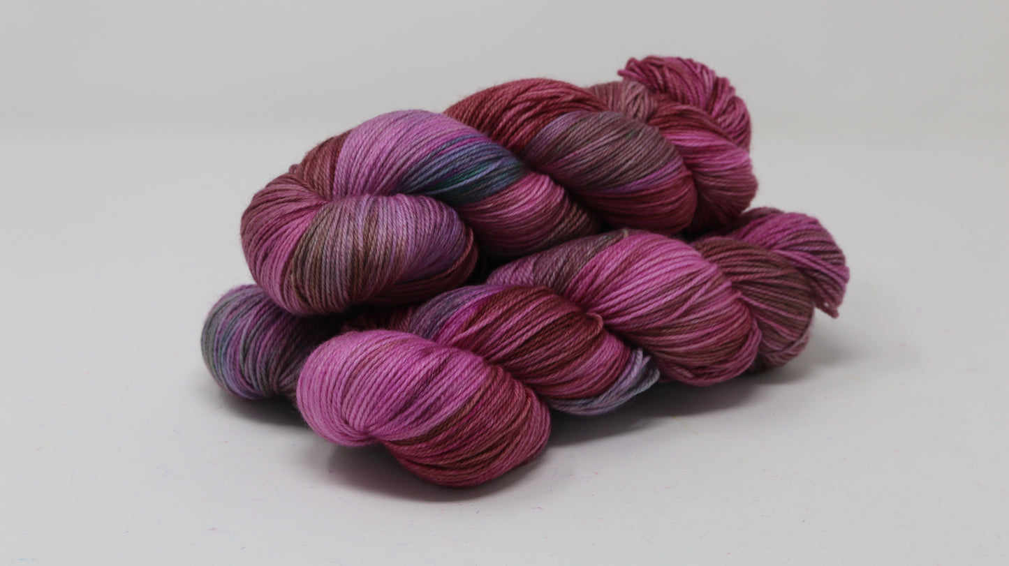 3 skeins of pink, red, green yarn