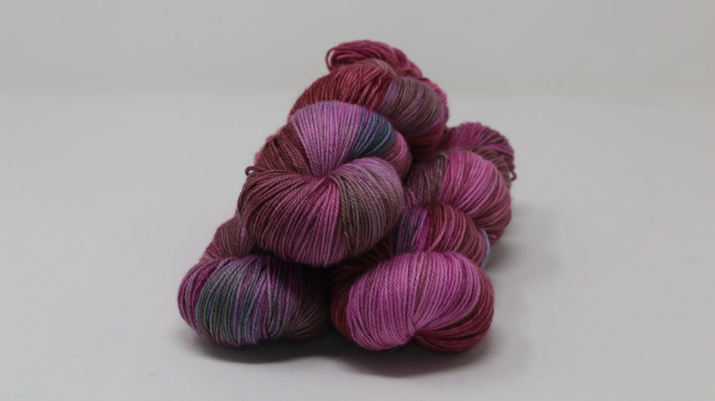 3 skeins of pink, red, green yarn