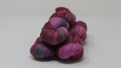 3 skeins of pink, red, green yarn