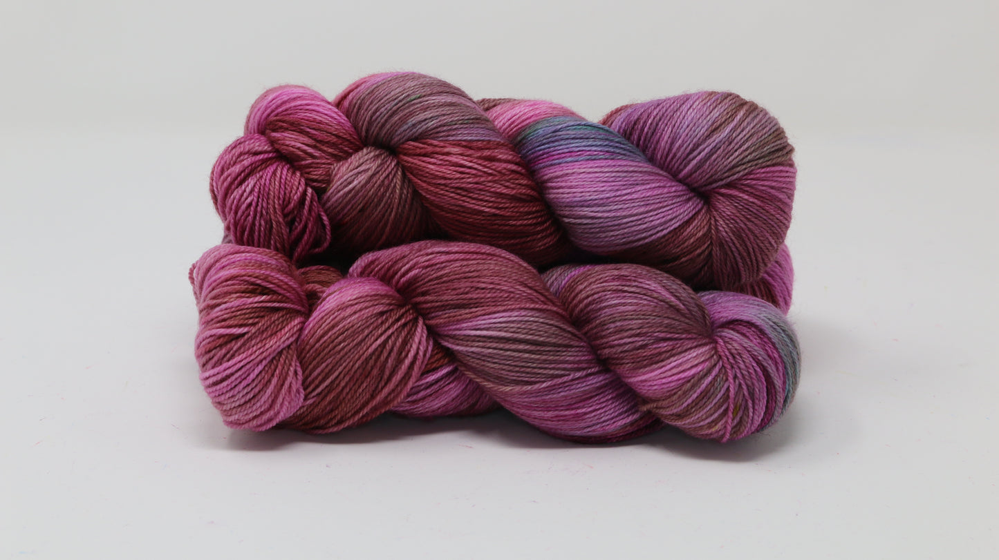 3 skeins of pink, red, green yarn