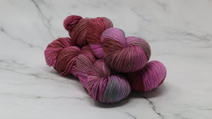 3 skeins of pink, red, green yarn