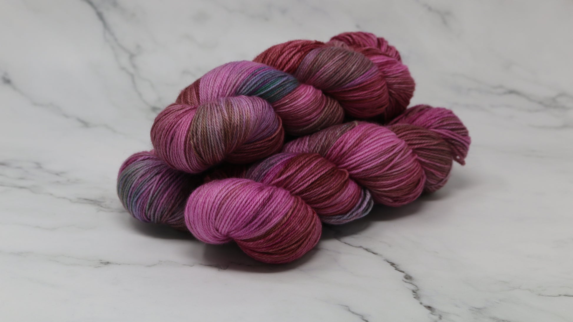 3 skeins of pink, red, green yarn
