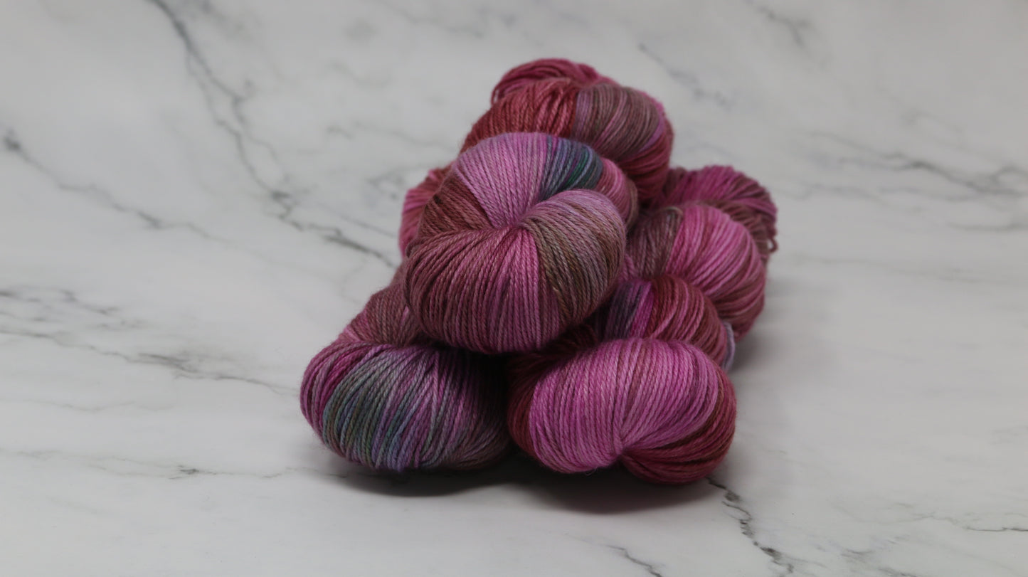 3 skeins of pink, red, green yarn