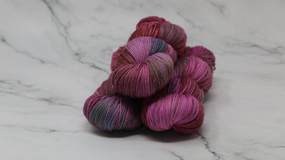 3 skeins of pink, red, green yarn