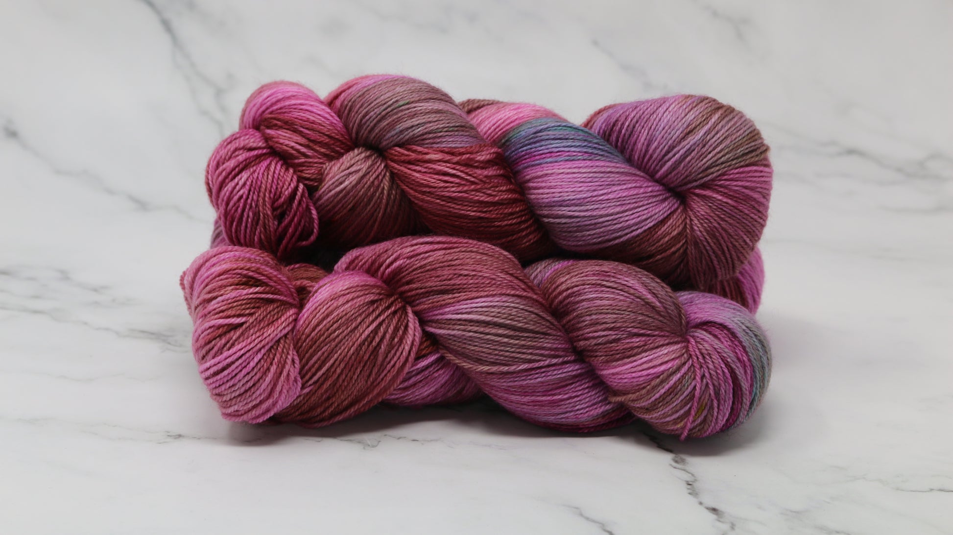 3 skeins of pink, red, green yarn